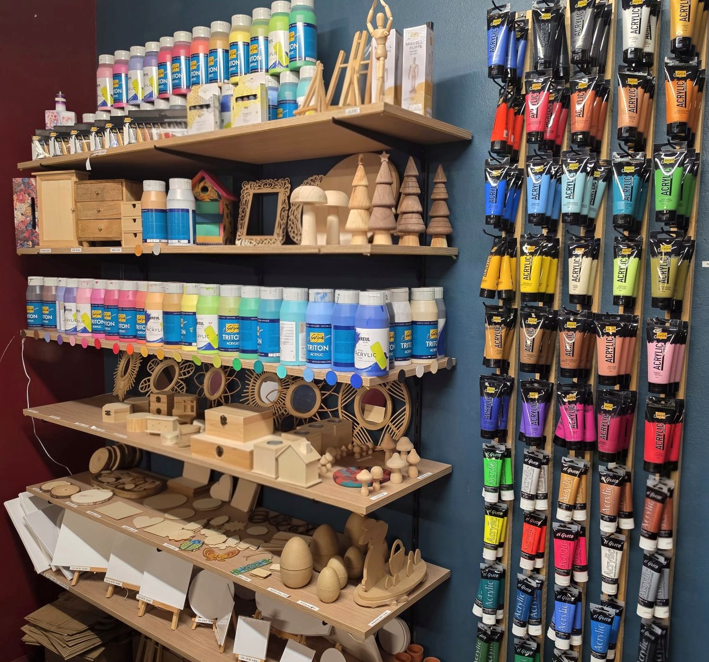 Acrylfarben und Holzrohlinge an der Wand im Atelier